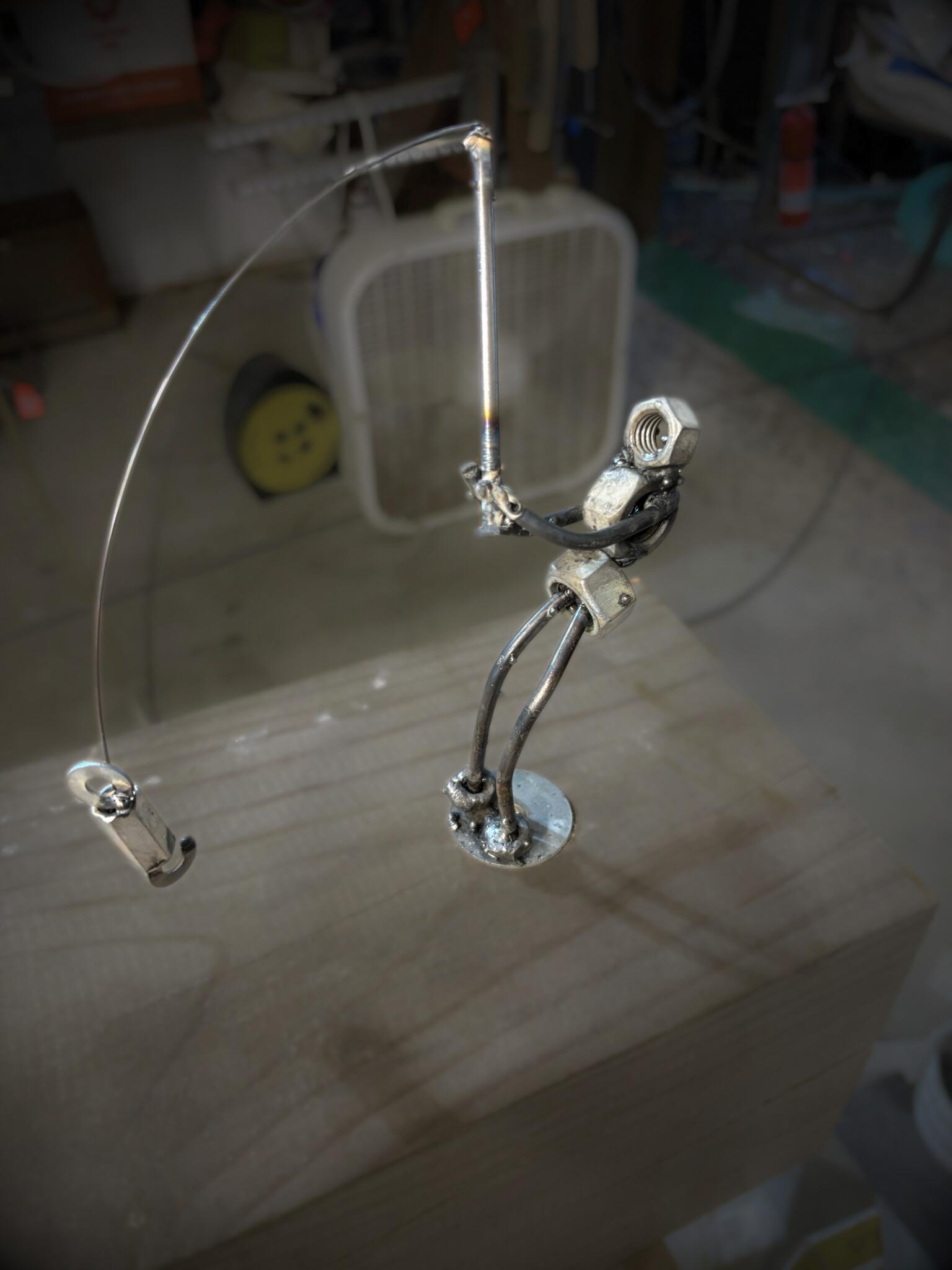 Photograph of metal art Fisherman pulling back his pole