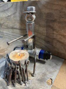 Warming by the fire Photograph of metal art camper Warming by the fire which is a candle and lighter holder