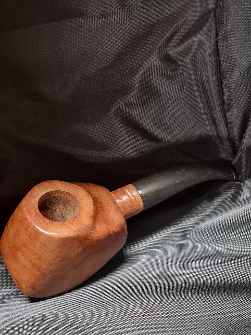 Tobacco pipe rack photograph with 3 custom made artisan crafted tobacco pipes different styles resting in hand carved pipe rack