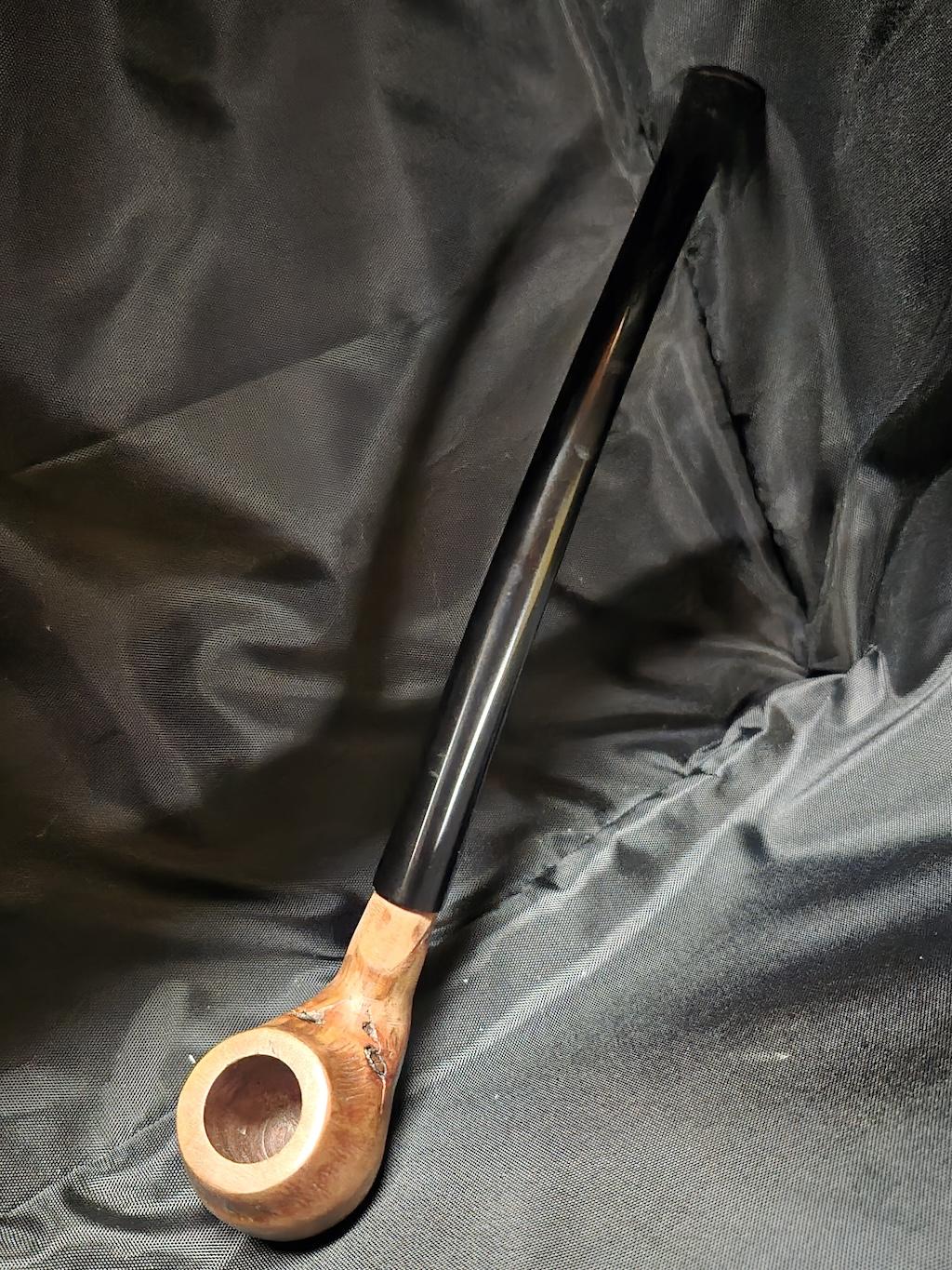 Tobacco pipe rack photograph with 3 custom made artisan crafted tobacco pipes different styles resting in hand carved pipe rack