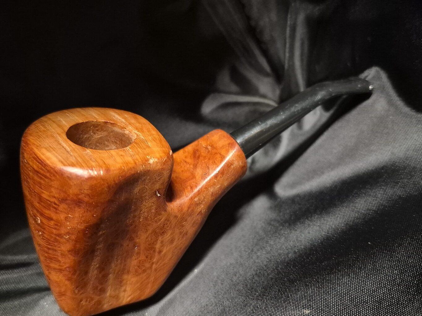 Tobacco pipe rack photograph with 3 custom made artisan crafted tobacco pipes different styles resting in hand carved pipe rack