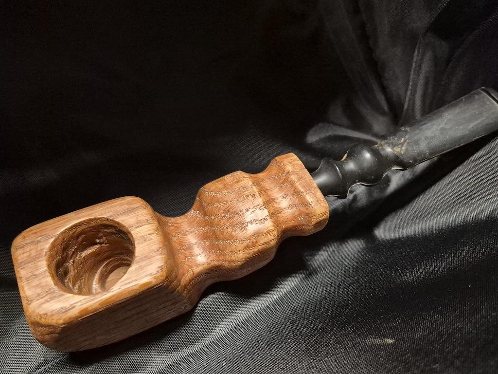 Tobacco pipe rack photograph with 3 custom made artisan crafted tobacco pipes different styles resting in hand carved pipe rack